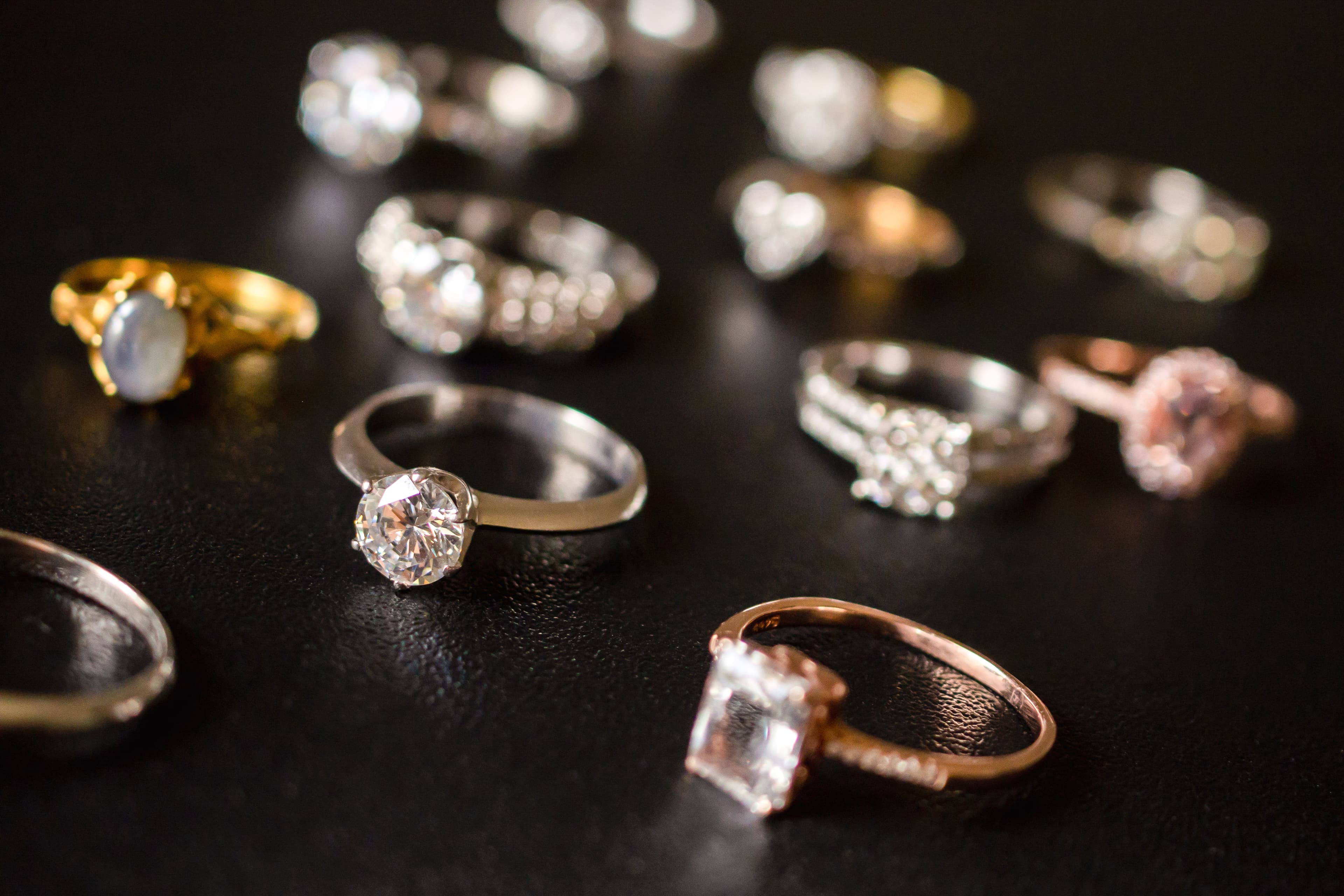 Six yellow gold engagement rings laid out by setting style — solitaire, hidden halo, halo, three-stone, bezel and toi et moi