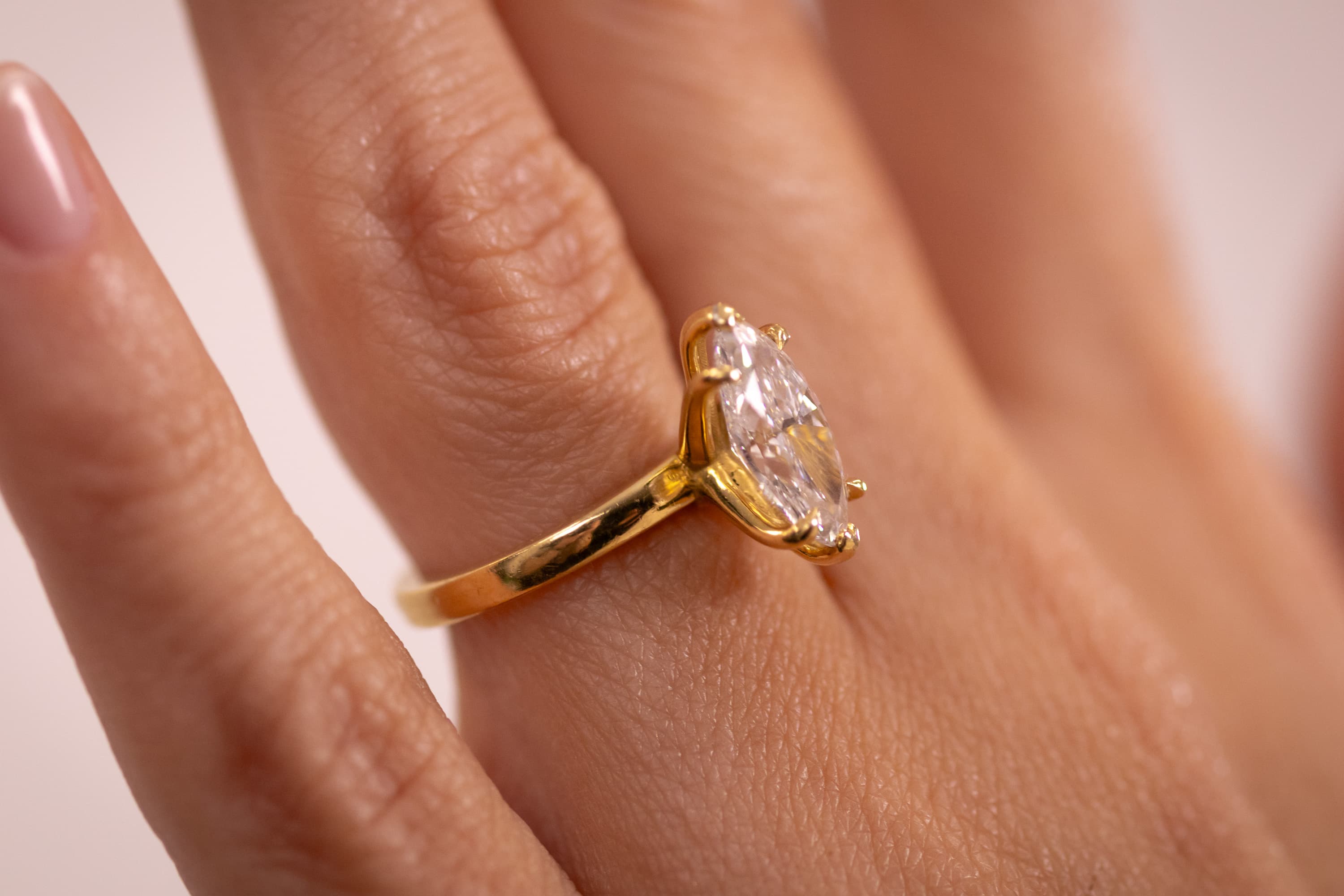 A yellow gold halo engagement ring with a round centre stone encircled by a fine diamond halo