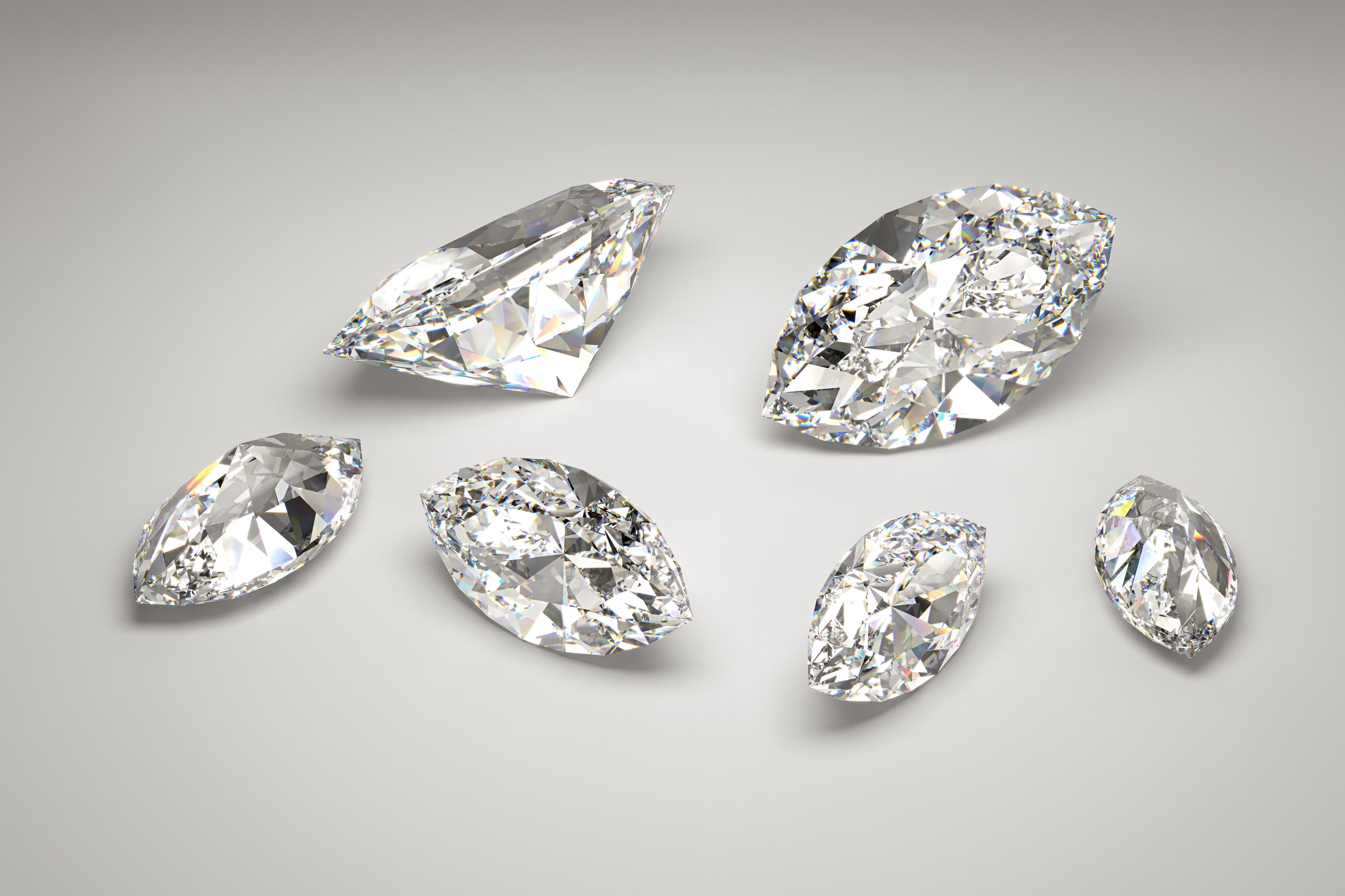 A jeweller holding a loose brilliant-cut diamond in tweezers up to the light